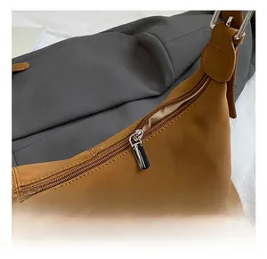 Detailed close-up of a brown leather crossbody bag with high-quality silver metal zipper