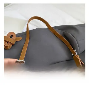 Close-up of adjustable brown leather strap with silver metal buckle on crossbody bag