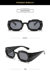 Detail view of black Y2K petal-shaped sunglasses with wavy frames and dark lenses