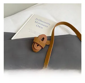 Close-up of adjustable brown PU leather shoulder strap with neat stitching and metal buckle