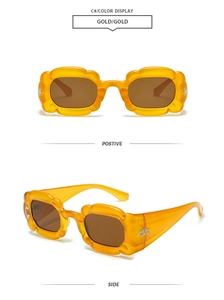 Macro detail of amber wave-edge Y2K sunglasses with dark brown lenses and wide temples