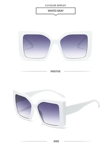 Detail view of large square sunglasses in white frame with grey gradient lenses