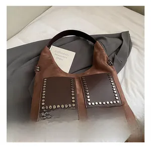Detail der Vintage braunen Wildleder-Tragetasche mit Bronze-Nieten auf Ledertaschen