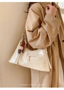 Sac fourre-tout chic en similicuir crème avec pompon décoratif et poche zippée latérale