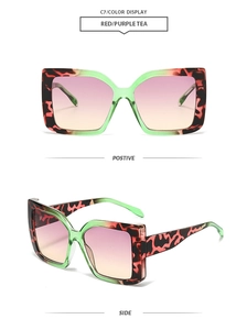 Detail view of square leopard print sunglasses with red, black and green contrast frames