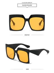 Detail view of bold square sunglasses with black frames and bright yellow lenses