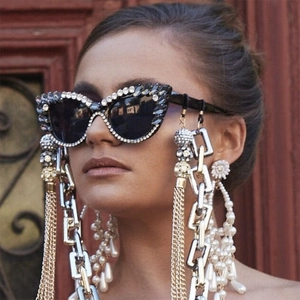 Detailed close-up of cat-eye sunglasses featuring rhinestone frames and pearl tassel chains