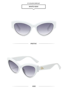 Detail view of white cat eye sunglasses with gray gradient lenses and gold logo