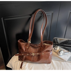 Détail du sac cabas en cuir ciré marron vintage avec boucle dorée et lanière de style