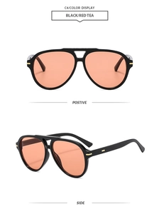 Detail of vintage aviator sunglasses with black frame, orange lenses and gold metal accents