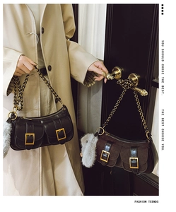 Detail of vintage dumpling bags with metal chain straps and plush rabbit charms