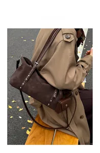 Detail of vintage brown suede shoulder bag with silver rivets and small matching coin purse