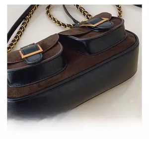 Detail of brown suede and black leather patchwork bag with gold buckle hardware