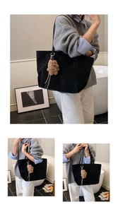 Detail of minimalist black suede tote bag featuring a cute brown plush bear charm
