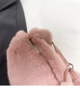 Close-up of pink faux fur shoulder bag detailing silver metal zipper and smooth PU strap