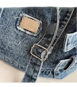 Détail du sac bandoulière en jean bleu foncé avec sangle réglable et boucle en métal