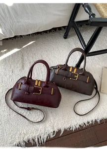 Detailed view of vintage-style faux leather handbags in wine red and dark brown