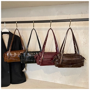 Detail view of four vintage faux leather shoulder bags in different colors on hooks