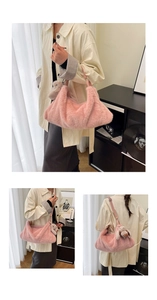 Detailed view of a soft pink plush handbag featuring a cute grey rabbit charm accessory