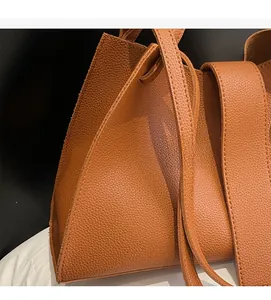 Close-up of brown pebble grain leather texture on minimalist shoulder bag strap
