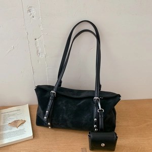 Detail of black suede tote bag showing the textured finish, silver studs and small pouch