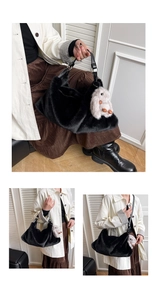 Detail of black plush handbag with gray rabbit charm and leather handle close-up