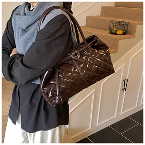Gros plan détaillé du sac cabas matelassé marron foncé en cuir verni brillant