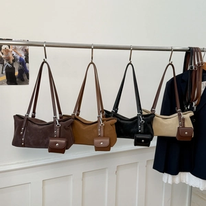 Detail of four matte suede Boston bags in earth tones with matching mini coin purses