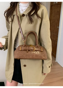 Detail view of brown vintage shell bag with retro buckle on a trench coat model