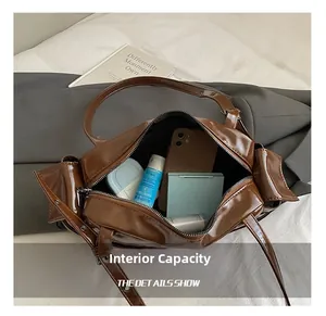 Detail shot of the spacious main compartment of this brown glossy faux leather shoulder bag