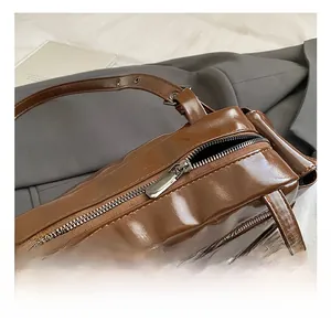 Detail of silver metal zipper and polished brown leather on vintage shoulder bag