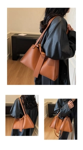 Detail view of caramel brown leather tote bag with unique wide strap and spacious design