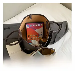 Macro view of spacious brown leather bucket bag interior with a white zip organizer