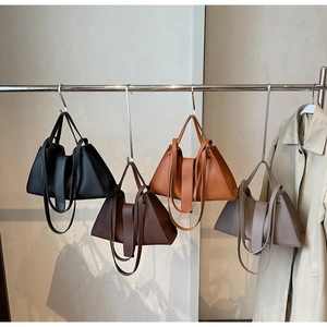 Litchi pattern leather dumpling bags in four colors displayed on a metal rack