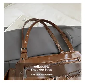 Detail of adjustable shoulder strap and metal buckle on dark brown bowling bag