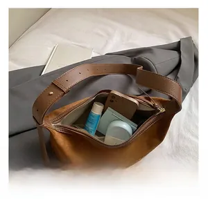 Intérieur spacieux du sac hobo en daim marron montrant l'espace de rangement
