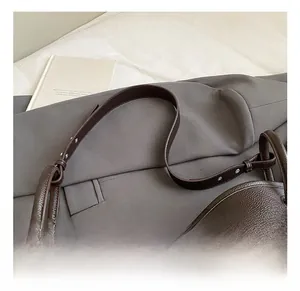 Close-up of brown lychee grain leather bucket bag with adjustable strap and silver buckle