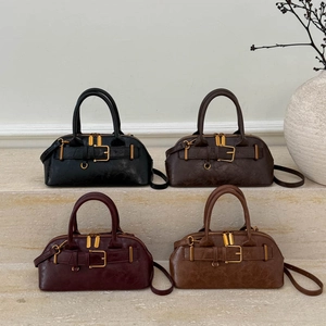Four vintage Boston handbags in black, coffee, burgundy and caramel on stone steps