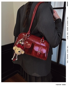 Détail du sac à bandoulière en PU brillant bordeaux avec deux poches et breloque ours