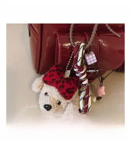 Porte-clé chiot blanc en peluche avec nœud léopard rouge sur sac en cuir verni rouge