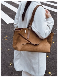 Gros plan d'un grand sac cabas en daim marron avec lanières en cuir dans la rue