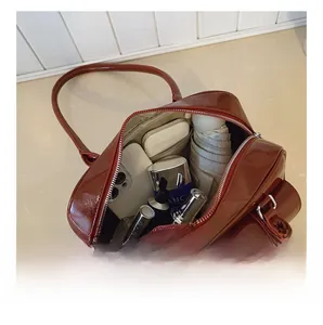 Détail du compartiment intérieur spacieux du sac à bandoulière en cuir verni rouge