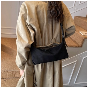 Détail du sac à bandoulière en daim noir avec une silhouette rectangulaire rétro chic
