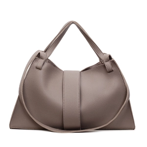 Detailed macro view of litchi grain leather texture on taupe crescent handbag