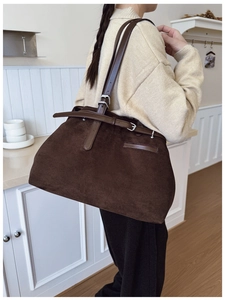 Détail du cabas en daim avec bandoulières en cuir marron et boucles métalliques vintage