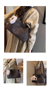 Detail der dunkelbraunen Vintage-Tragetasche mit Kontrastnaht und Plüsch-Hasenanhänger