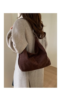 Detail view of large dark brown suede tote bag showing texture and adjustable leather strap