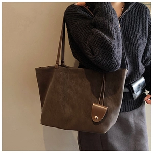 Deep coffee brown matte leather tote bag detail with slim shoulder straps and mini pouch charm