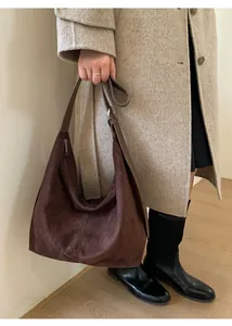 Detail of vintage matte brown hobo bag with adjustable leather strap and silver ring hardware