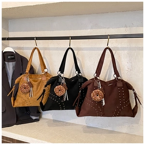 Trois sacs cabas vintage à rivets en jaune moutarde, noir et marron avec breloques